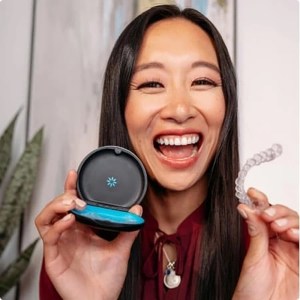 Woman holding an Invisalign clear aligners and case.